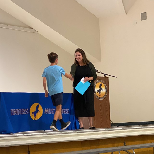Student receiving award from Mrs. Rushall